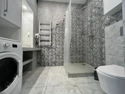 a bathroom with a shower and a washing machine at Krakow Views - Stylish Apartments in Kazimierz in Kraków