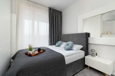 a bedroom with a large bed and a mirror at Lubicz Stylish Apartment with Parking and Air Conditioning in the City Center by Noclegi Renters in Kraków
