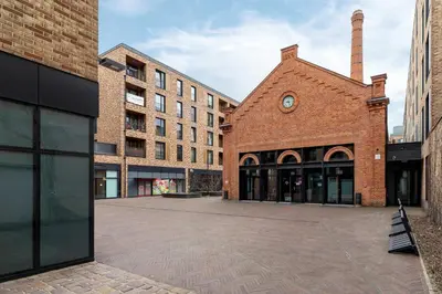a brick building with a clock on the side of it at Lubicz Stylish Apartment with Parking and Air Conditioning in the City Center by Noclegi Renters in Kraków