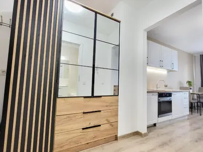 a kitchen with white cabinets and a large glass wall at Royal Smart Apartment in Kraków
