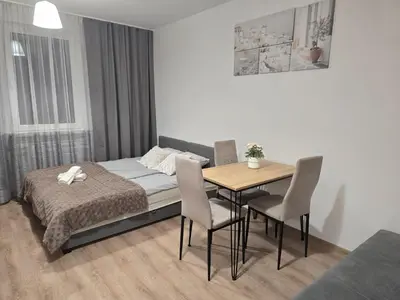 a bedroom with a bed and a table and chairs at Royal Smart Apartment in Kraków