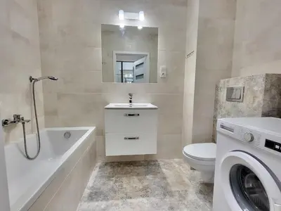 a bathroom with a sink toilet and a washing machine at Royal Smart Apartment in Kraków