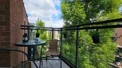 a balcony with a table and a chair on a patio at Apartamenty Figaretti Rakowicka in Kraków