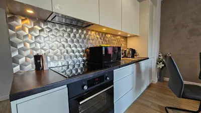 a kitchen with a counter top with a microwave at Apartamenty Figaretti Rakowicka in Kraków