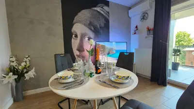 a dining room table with a picture of a woman at Apartamenty Figaretti Rakowicka in Kraków