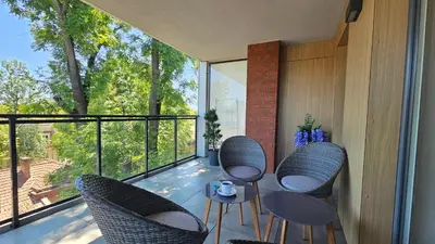 a balcony with chairs and a table with a view at Apartamenty Figaretti Rakowicka in Kraków
