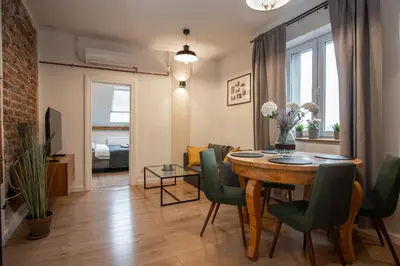 a living room with a dining room table and chairs at Apartamenty Borek przy Modrej in Kraków