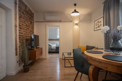 a living room with a dining room table and a living room at Apartamenty Borek przy Modrej in Kraków