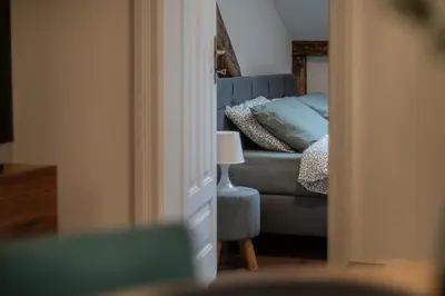 a bedroom with a bed and a blue couch at Apartamenty Borek przy Modrej in Kraków