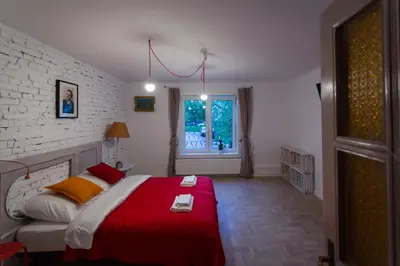 a bedroom with a red and white bed and a window at Pilotow 87 Apartments in Kraków