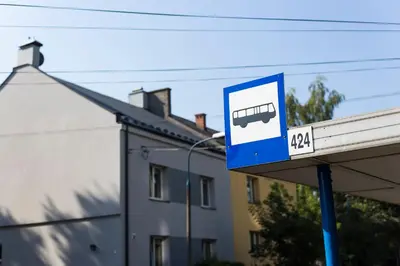 a bus stop sign in front of a building at Pilotow 87 Apartments in Kraków