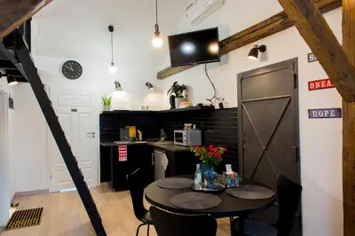 a room with a table with chairs and a tv on the wall at Pilotow 87 Apartments in Kraków