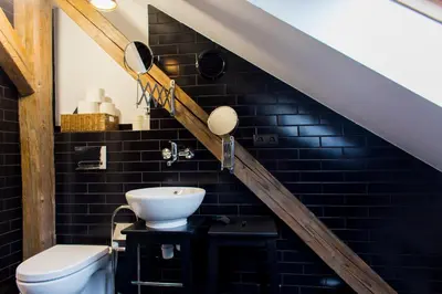 a bathroom with a sink and a toilet under the stairs at Pilotow 87 Apartments in Kraków