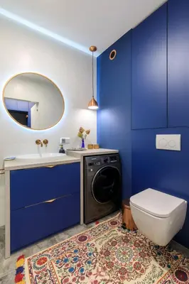 a blue bathroom with a washing machine and a sink at Soho Residence in Kraków