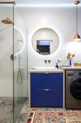 a bathroom with a sink and a washing machine at Soho Residence in Kraków