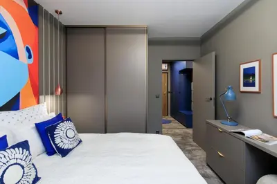 a bedroom with a bed with blue pillows at Soho Residence in Kraków