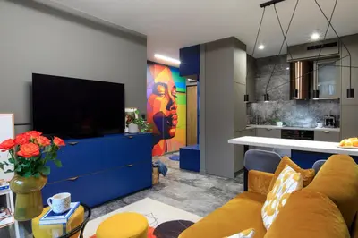 a living room with a large tv and a kitchen at Soho Residence in Kraków