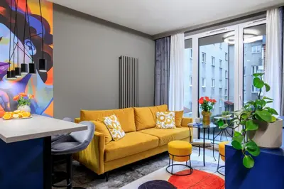 a living room with a yellow couch and a window at Soho Residence in Kraków