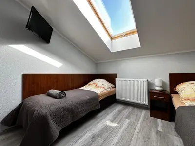 a living room with two beds and a red couch at Apartament Serwis in Kraków