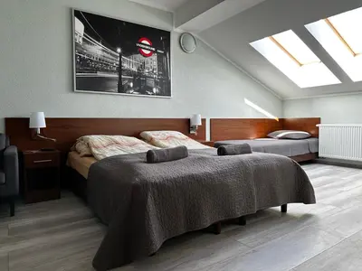 a bedroom with two beds and a skylight at Apartament Serwis in Kraków