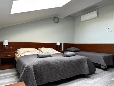 a bedroom with two beds and a skylight at Apartament Serwis in Kraków