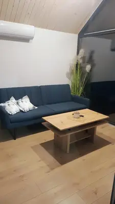 a living room with a blue couch and a coffee table at Wiatrem Pisane in Roczyny