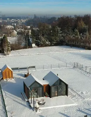 a house on top of a snow covered field at Wiatrem Pisane in Roczyny