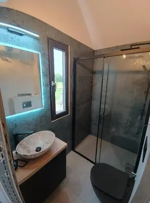a bathroom with a sink and a glass shower at Wiatrem Pisane in Roczyny