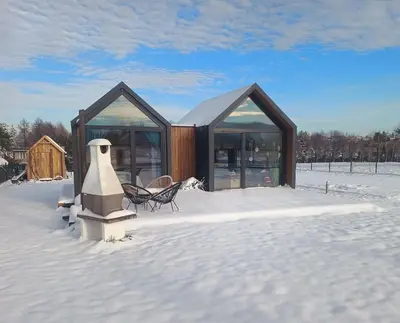 a house in the snow with a table and chairs at Wiatrem Pisane in Roczyny