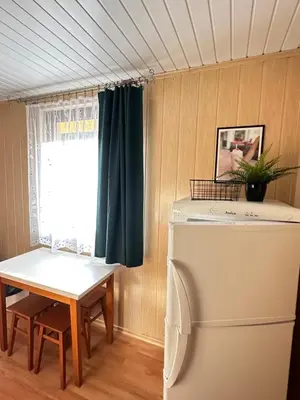 a room with a table and a refrigerator and a window at Ponikiew Resort in Wadowice