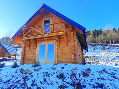 a log cabin with snow on the ground at Domek na Przełęczy 2 in Wierzbanowa