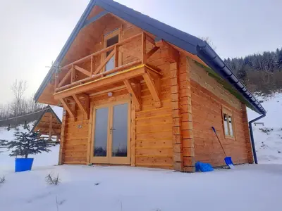 a log cabin in the snow with at Domek na Przełęczy 2 in Wierzbanowa