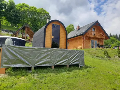 a house with a cover on the grass in front of it at Domek na Przełęczy 2 in Wierzbanowa