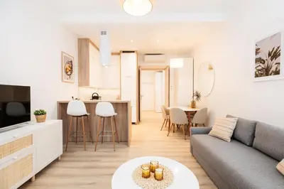 a living room and kitchen with a couch and a table at Kołłątaja Spacious Modern Apartment - by Upstairs in Kraków