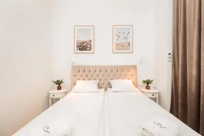 a bedroom with a large white bed with two tables at Kołłątaja Spacious Modern Apartment - by Upstairs in Kraków