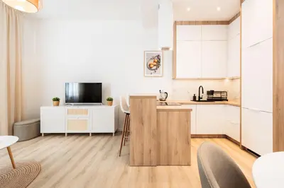 a kitchen with white cabinets and a counter top at Kołłątaja Spacious Modern Apartment - by Upstairs in Kraków