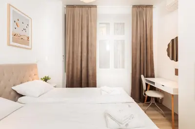 a hotel room with two beds and a desk at Kołłątaja Spacious Modern Apartment - by Upstairs in Kraków