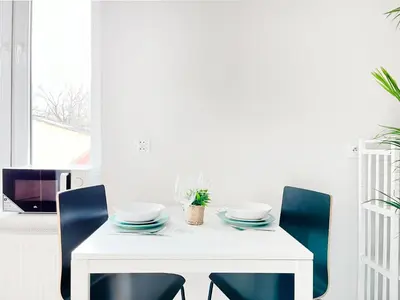 a white dining room table with two bowls and chairs at Cozy Apartment for family next to Wawel & Old Town in Kraków