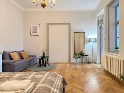 a living room with a bed and a couch at Cozy Apartment for family next to Wawel & Old Town in Kraków