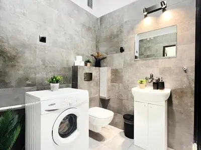a bathroom with a washing machine and a toilet at Cozy Apartment for family next to Wawel & Old Town in Kraków