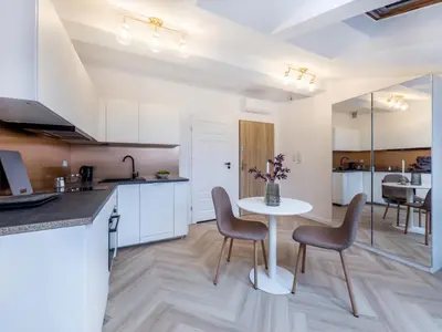 a kitchen and living room with a table and chairs at Apartament Długa 82 in Kraków