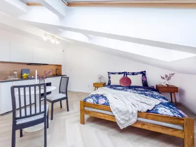 a bedroom with a bed and a table and chairs at Apartament Długa 82 in Kraków