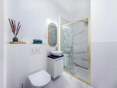a bathroom with a toilet and a sink and a mirror at Apartament Długa 82 in Kraków
