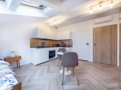 a kitchen with white cabinets and a table in a room at Apartament Długa 82 in Kraków