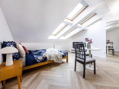 a bedroom with a bed and a dining room with skylights at Apartament Długa 82 in Kraków