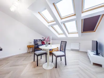 a dining room with skylights and a table and chairs at Apartament Długa 82 in Kraków