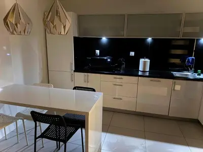 a kitchen with a white table and some chairs at Apartament Bajeczny 87 - 5 min to Tauron Arena Cracow - beside the Vistula River in Kraków