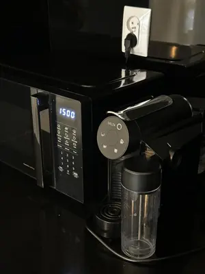 a black coffee maker with a glass in front of it at Apartament Bajeczny 87 - 5 min to Tauron Arena Cracow - beside the Vistula River in Kraków