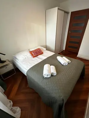 a small bedroom with a bed with slippers on it at Apartament Bajeczny 87 - 5 min to Tauron Arena Cracow - beside the Vistula River in Kraków
