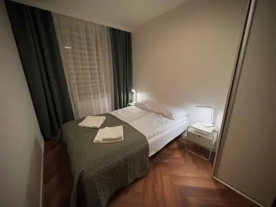 a small bedroom with a bed with two towels on it at Apartament Bajeczny 87 - 5 min to Tauron Arena Cracow - beside the Vistula River in Kraków